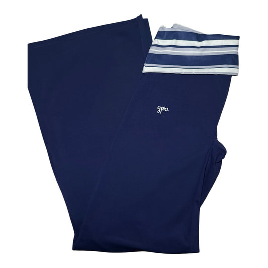 A pair of navy blue sweatpants folded to show the interior side, featuring a striped cuff in navy, white, and light blue, with a small white embroidered logo on the leg.